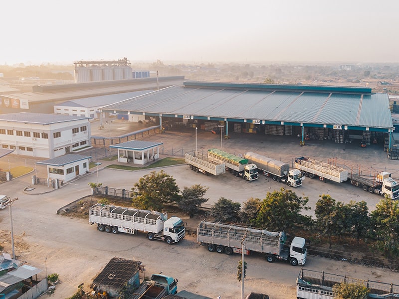 An aerial view of a large logistics facility with lots of HGVs in loading bays.